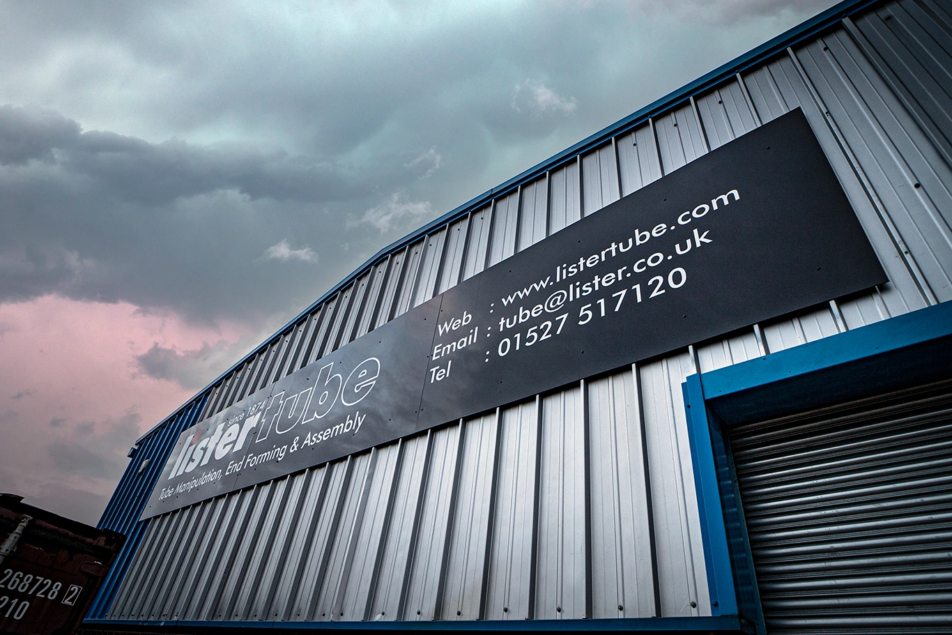 Exterior of warehouse building with listertube name board and contact details